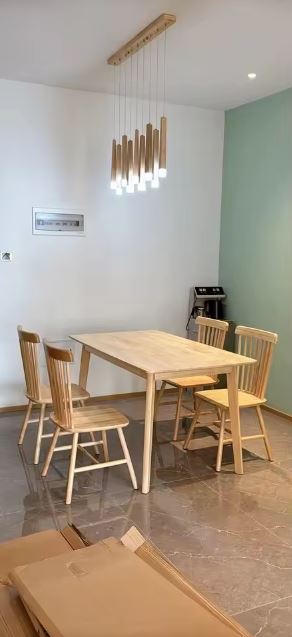 Suspension tubes en bois avec LED au style naturel et contemporain au-dessus d’une table de salle à manger.