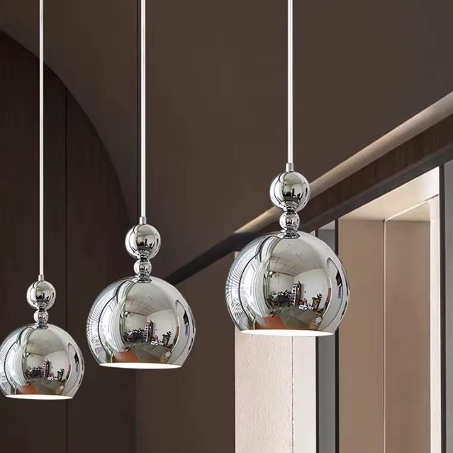 Trio de suspensions boules argentées modernes offrant une lumière élégante et un style contemporain.