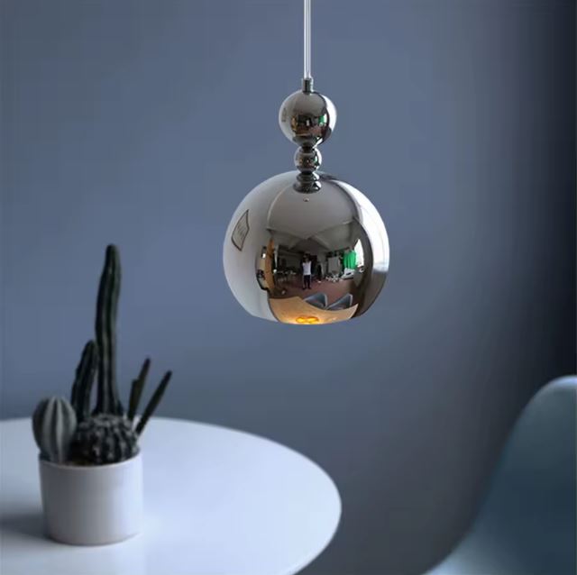 Suspension boule argentée design unique, parfaite pour un éclairage contemporain dans un espace moderne.