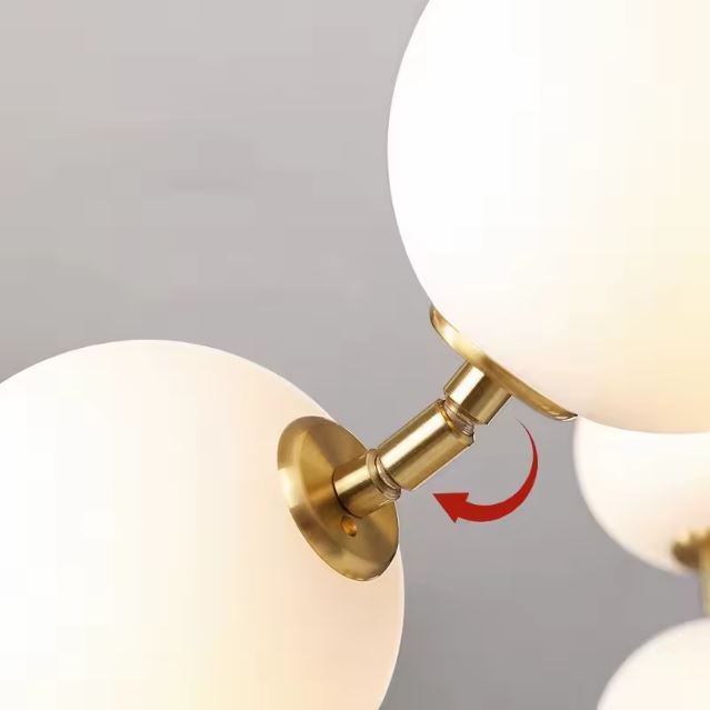 Détail de la suspension boule blanche et doré avec une finition en métal doré et un globe en verre opale.