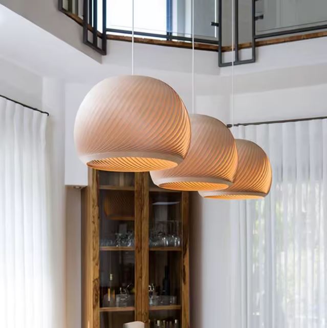 Suspension boule en bois sculpté offrant une lumière chaleureuse et tamisée, idéale pour une ambiance moderne et naturelle dans votre intérieur.