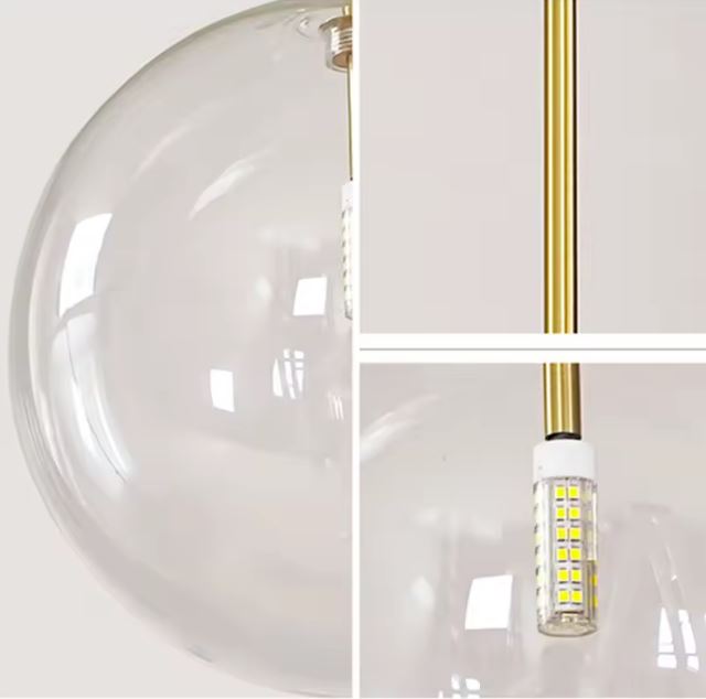 Zoom sur la suspension boule en verre transparent avec un éclairage LED moderne et un support métallique doré pour un style élégant.