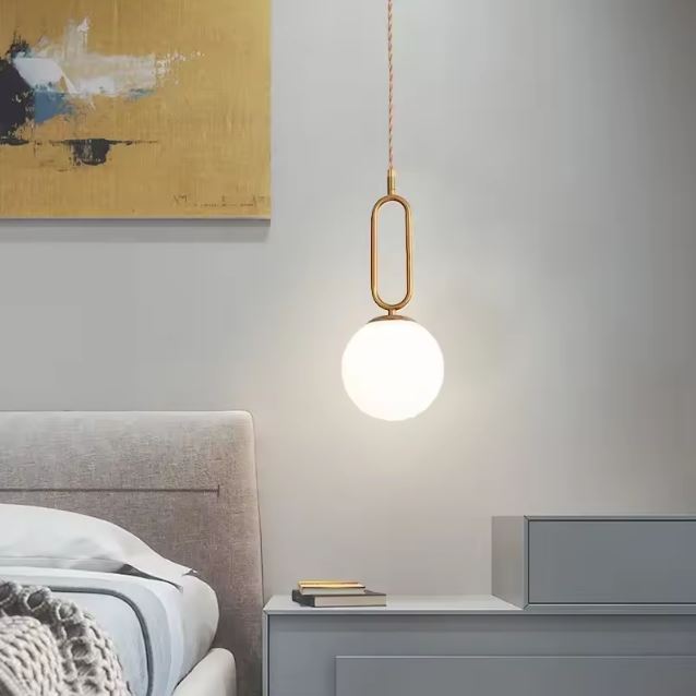 Suspension boule opaline en laiton pour chambre, luminaire néo-rétro élégant au rendu doux et décoratif.