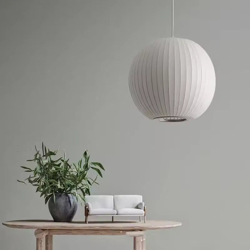 Suspension boule en soie blanche plissée au style minimaliste japonais, suspendue dans un intérieur épuré et naturel