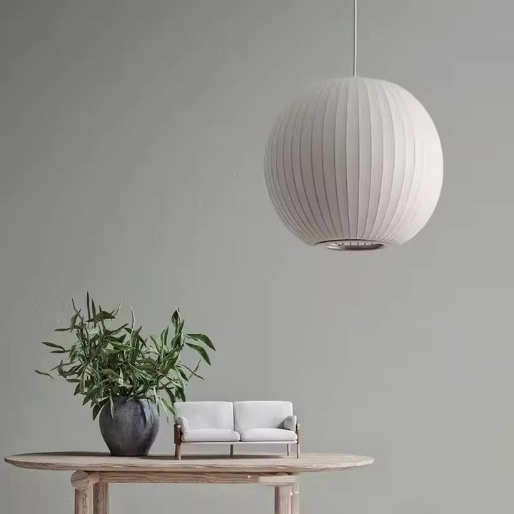 Suspension boule en soie blanche plissée au style minimaliste japonais, suspendue dans un intérieur épuré et naturel