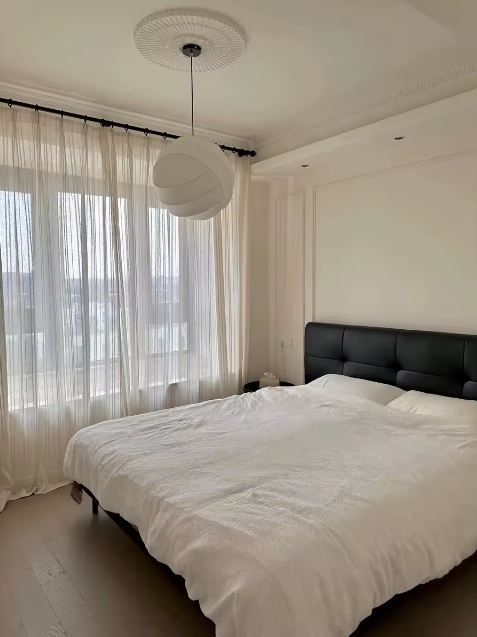 Suspension boule tissu japonais dans une chambre épurée diffusant une lumière douce au style japandi contemporain