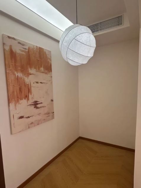 Suspension boule tissu japonais diffusant une lumière douce dans un couloir au style japandi et épuré