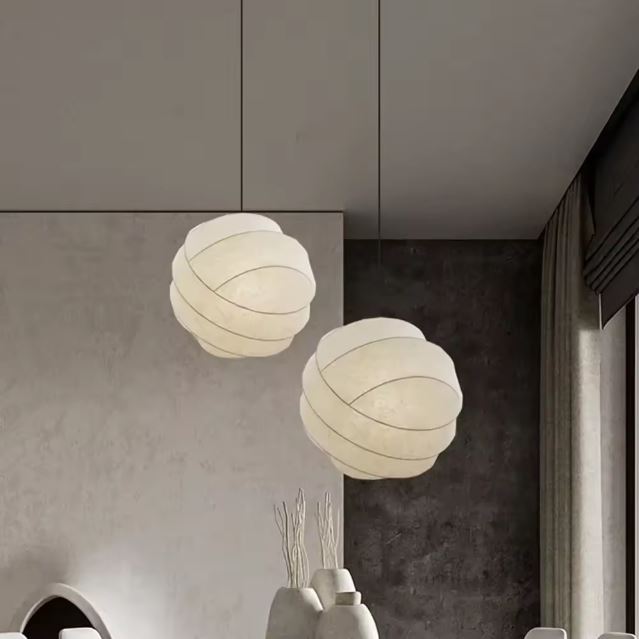 Suspension boule en tissu, un luminaire moderne et design pour embellir votre salon avec une lumière douce.