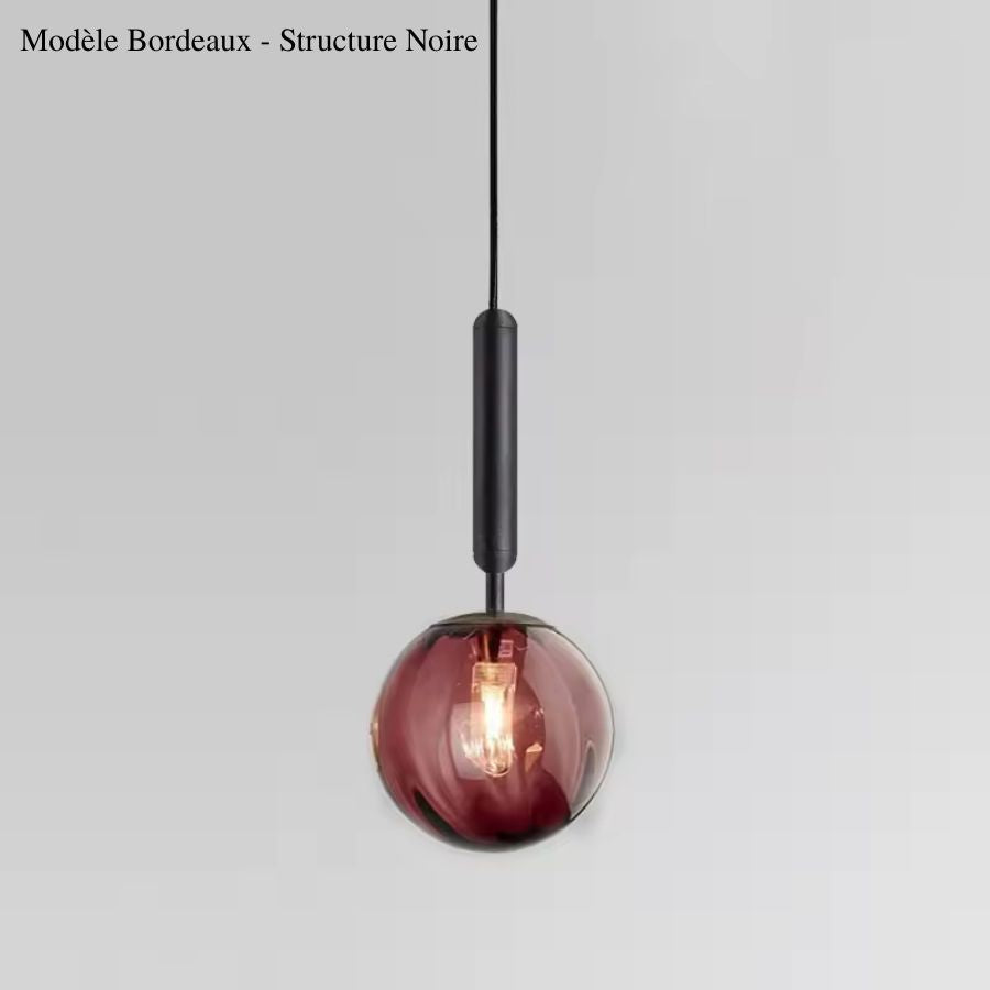 Sphère en verre bordeaux associée à une fine tige noire, une suspension colorée au style chic et contemporain