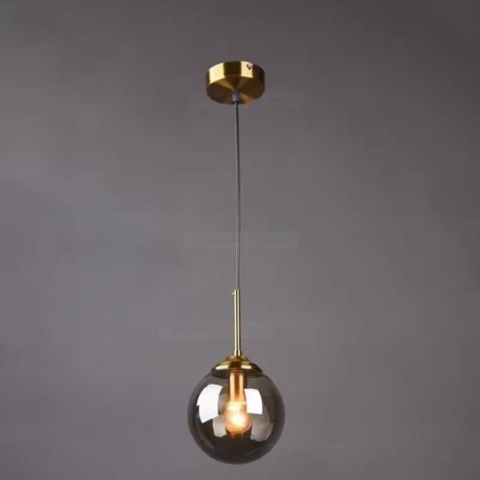 Suspension boule moderne en verre fumé et finition dorée, idéale pour créer une ambiance chaleureuse et sophistiquée.