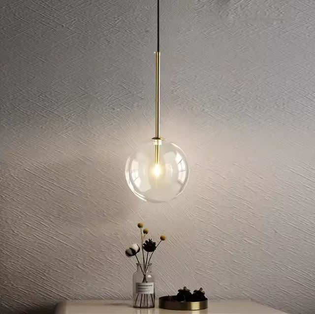 Suspension boule en verre transparent avec support en laiton, design élégant et moderne, parfaite pour une décoration intérieure raffinée et lumineuse.