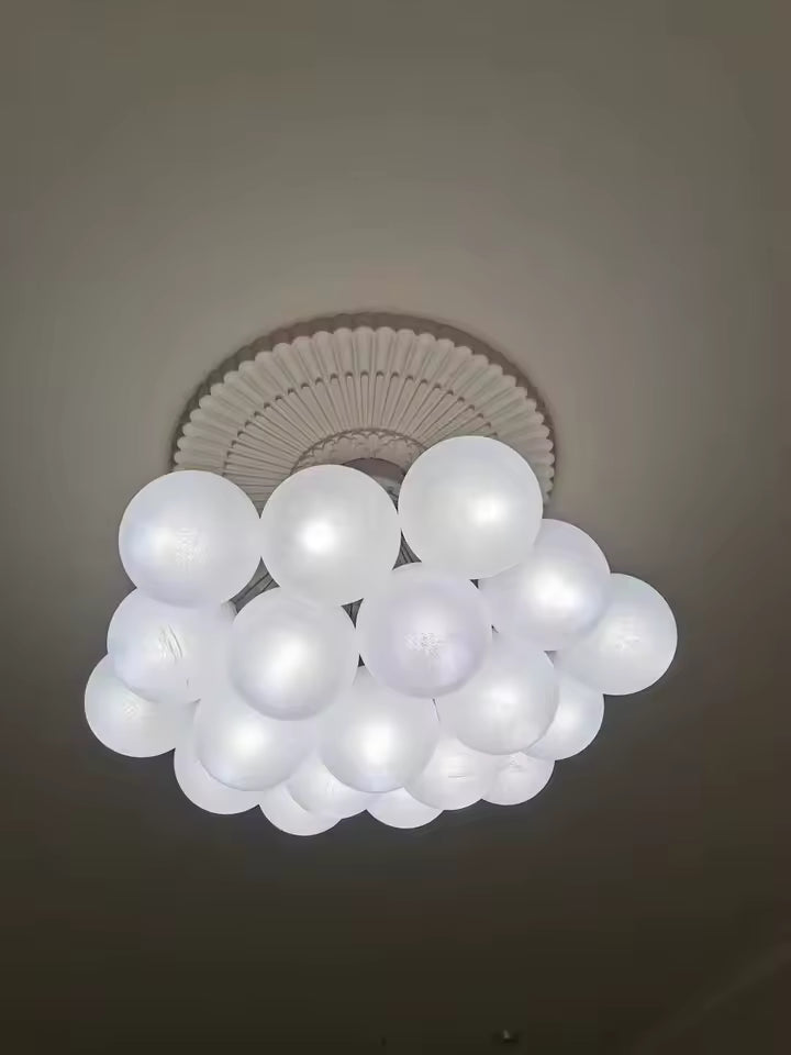 Vue de dessous d’une suspension nuage de boules blanches lumineuses au design sculptural et organique