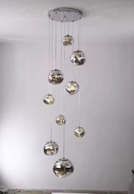 Suspension en cascade de boules effet miroir, luminaire contemporain pour cage d’escalier et grands volumes élégants.