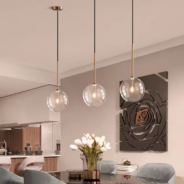 Suspension composée de trois boules en verre transparent, idéales pour un éclairage moderne et élégant dans votre salon ou salle à manger.