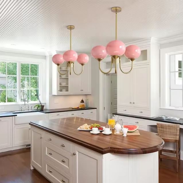 Suspension à boules rose opalin au style glamour vintage, luminaire élégant apportant douceur et caractère à la cuisine.