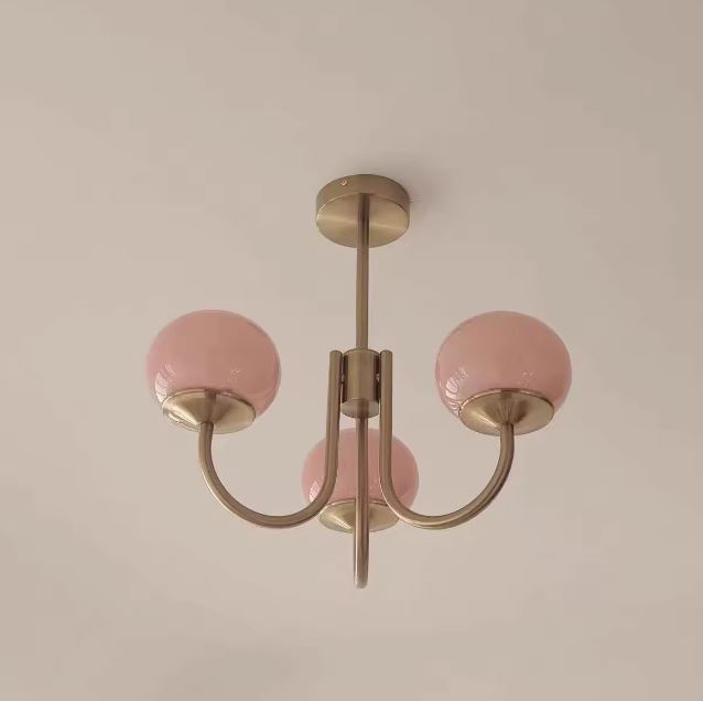 Suspension à boules rose pastel et laiton, luminaire rétro chic inspiré du design des années 50 revisité avec élégance.