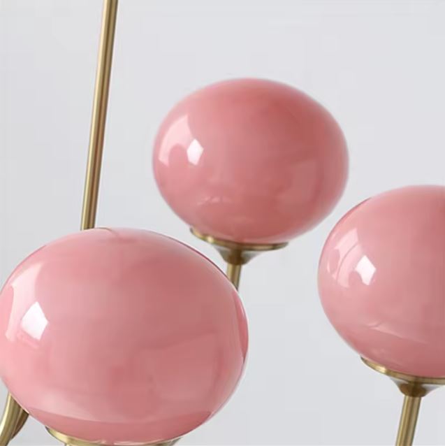Détail de suspension à boules en verre rose opalin, luminaire vintage chic aux accents rétro et féminins raffinés.