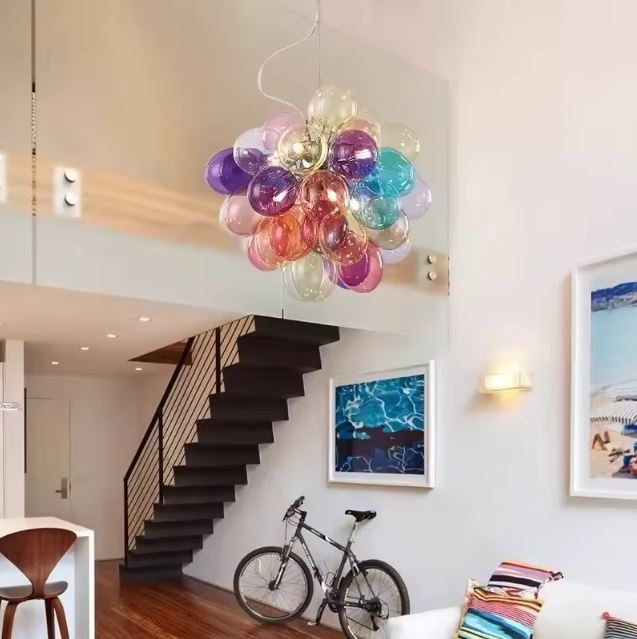 Suspension bouquet en verre coloré translucide dominant un escalier, dans un intérieur contemporain à l'esprit artistique.