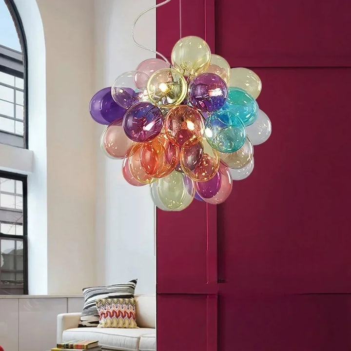 Suspension design en verre coloré translucide diffusant une lumière vive dans un salon moderne.