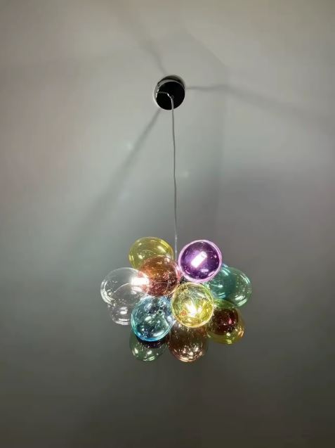 Vue de dessous d'une suspension en bouquet de globes colorés translucides, au design lumineux inspiré des bulles de verre.