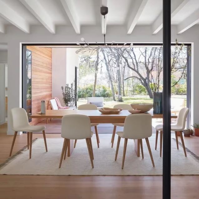 Suspension branche moderne au-dessus d’une salle à manger lumineuse, style organique et épuré créant une ambiance naturelle et élégante.