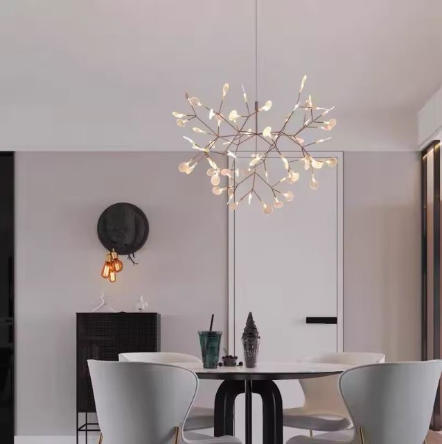 Suspension branche contemporaine illuminant une salle à manger moderne avec un style aérien et sculptural.