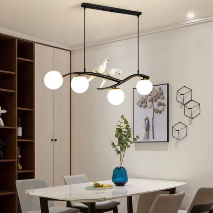 Suspension branche noire avec oiseaux et quatre globes opalins au style scandinave contemporain et organique