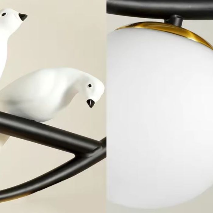 Détail d'une suspension branche avec oiseaux décoratifs et globe opalin au style nordique et design poétique