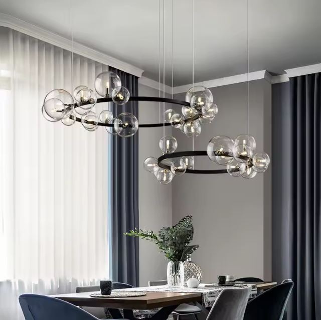 Double suspension bulle avec globes en verre transparent, idéale pour une salle à manger moderne et sophistiquée.