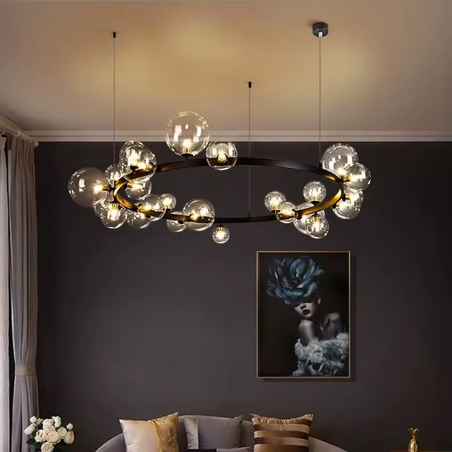 Suspension bulle avec globes en verre transparent, offrant une ambiance luxueuse et moderne dans un salon raffiné.