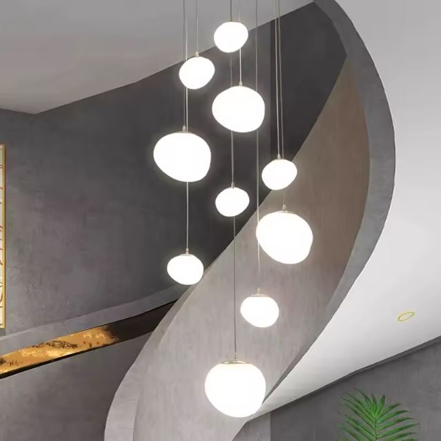 Suspension design pour cage d'escalier avec boules lumineuses modernes, créant une ambiance raffinée et chaleureuse.