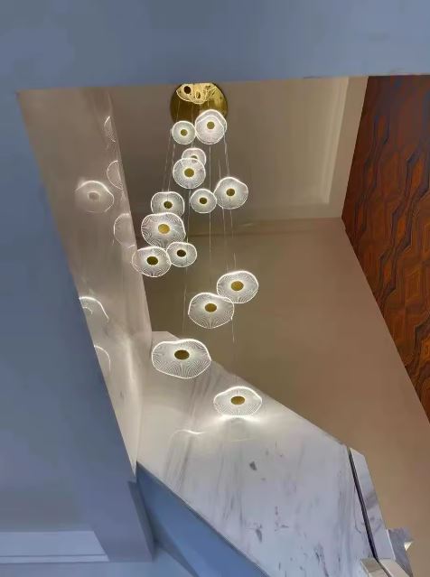 Suspension pour cage d’escalier à disques lumineux dorés, style aérien, élégant et résolument moderne.
