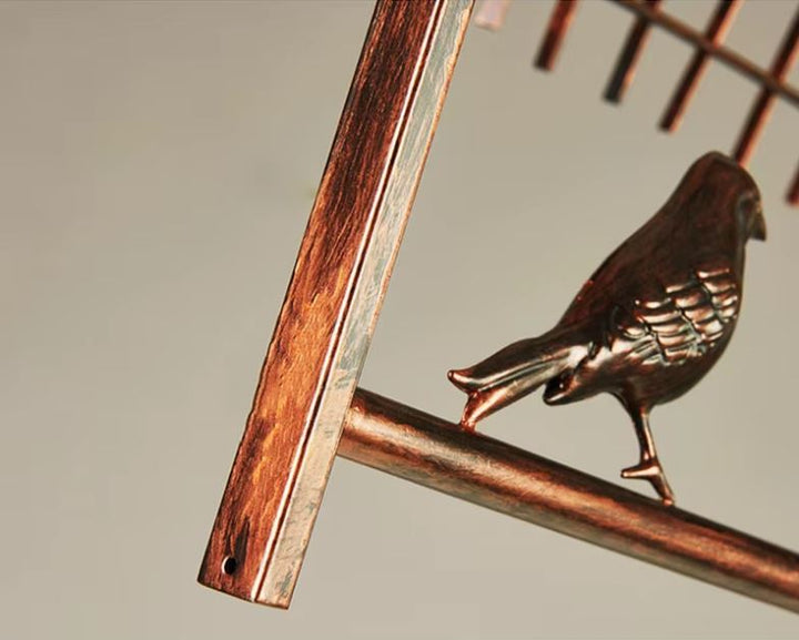 Détail de la structure en métal vieilli d'une suspension cage oiseau, un luminaire au design rustique et élégant.