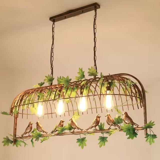 Suspension cage oiseau avec feuillage et ampoules vintage, un luminaire rustique pour une ambiance nature et cosy.