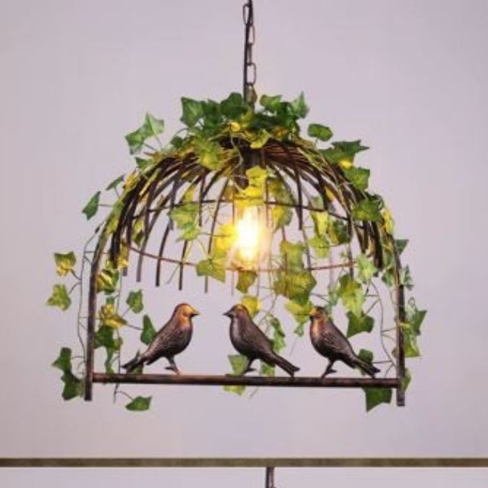 Suspension cage oiseau avec ampoule Edison et feuillage artificiel, un luminaire vintage idéal pour une ambiance nature et chaleureuse.