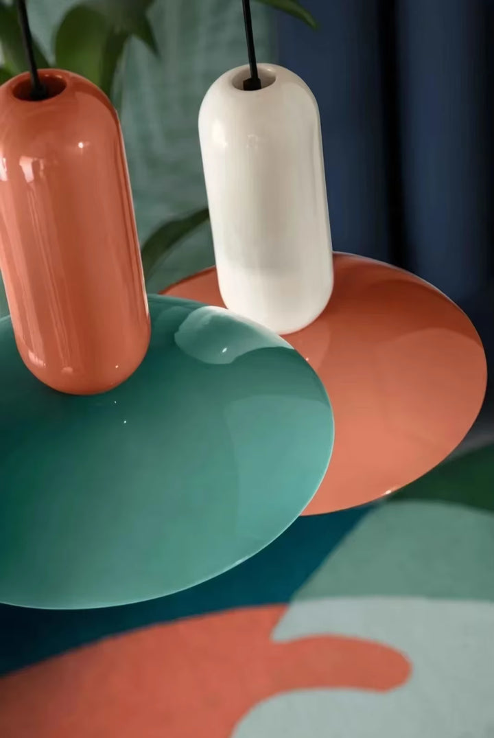 Gros plan sur deux suspensions Capsule Pop vertes et orange, aux formes arrondies inspirées du design Space Age