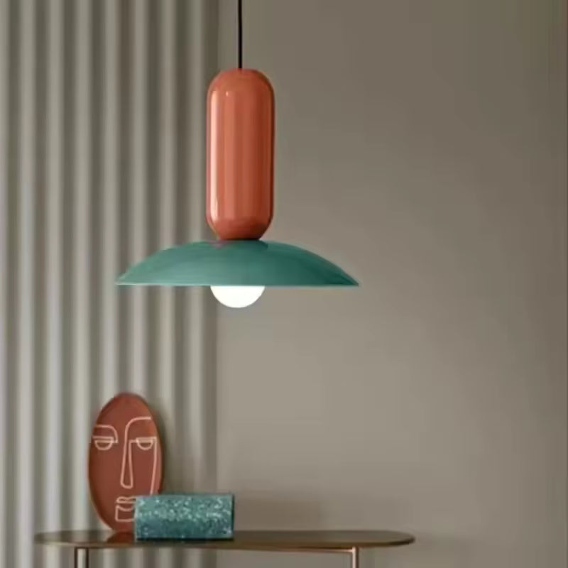 Suspension Capsule Pop verte et orange au design rétro ludique, avec disque bombé et silhouette graphique