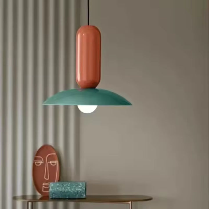 Suspension Capsule Pop verte et orange au design rétro ludique, avec disque bombé et silhouette graphique