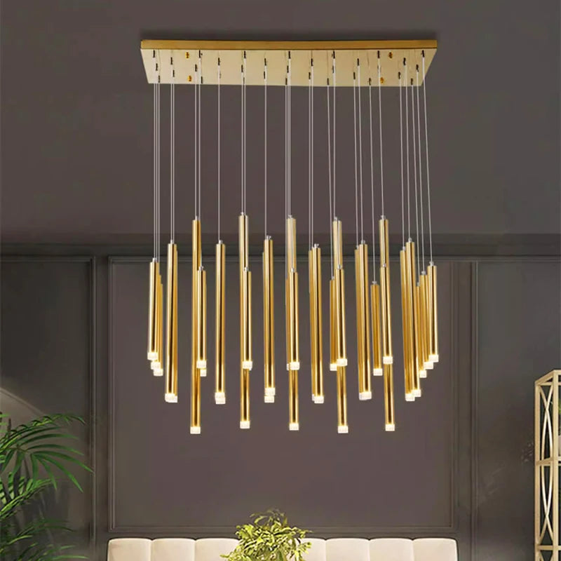 Suspension cascade moderne à tubes lumineux dorés installée dans un salon élégant.