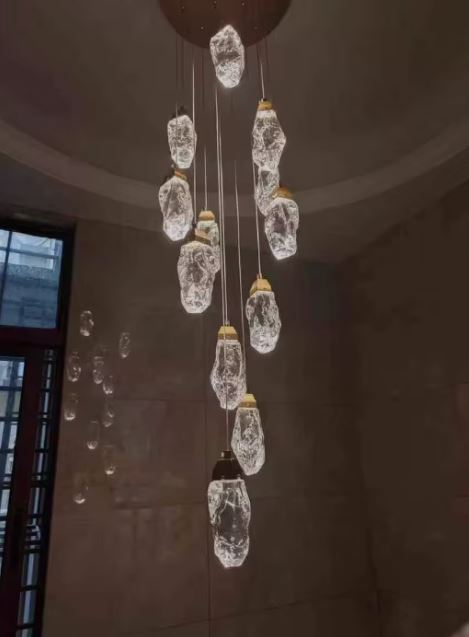 Suspension cascade en cristal au style minéral contemporain, luminaire spectaculaire idéal pour cage d’escalier ou hall d’entrée haut de plafond.