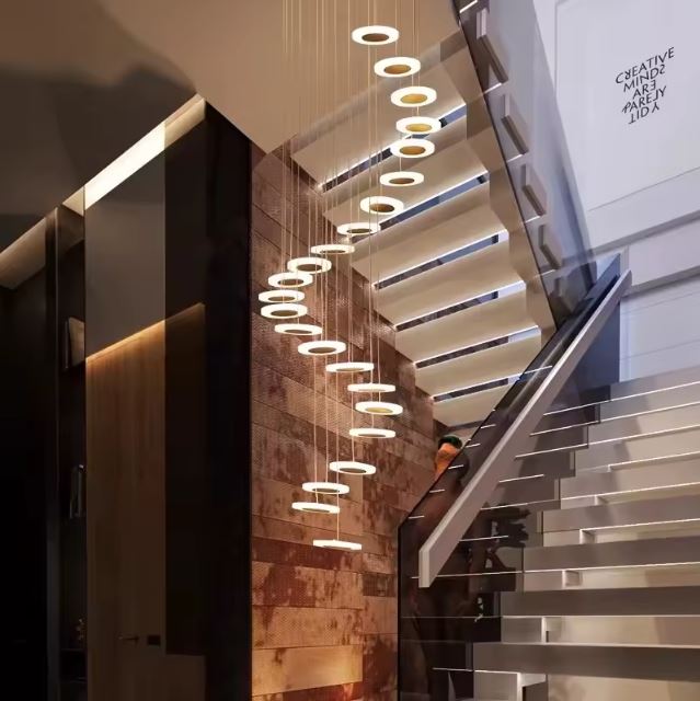 Suspension cascade élégante pour escalier intérieur moderne avec un éclairage LED sophistiqué.