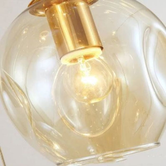 Détail de la Suspension Cascade de Globes en Verre montrant l’ampoule et la lumière diffusée à travers le verre pour un éclairage chaleureux et élégant