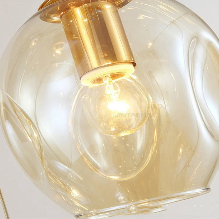 Détail de la Suspension Cascade de Globes en Verre montrant l’ampoule et la lumière diffusée à travers le verre pour un éclairage chaleureux et élégant