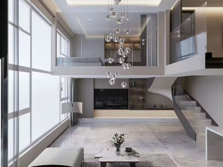 Suspension en cascade de globes en verre dans un séjour double hauteur avec escalier design et architecture contemporaine.