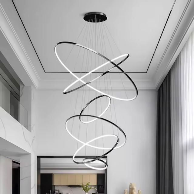 Suspension cascade grande hauteur noire LED au design élégant, idéale pour une salle à manger avec plafond haut et moderne.
