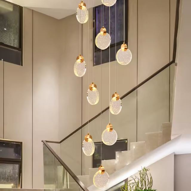 Suspension cascade moderne en cristal doré, parfaite pour un design d’escalier.