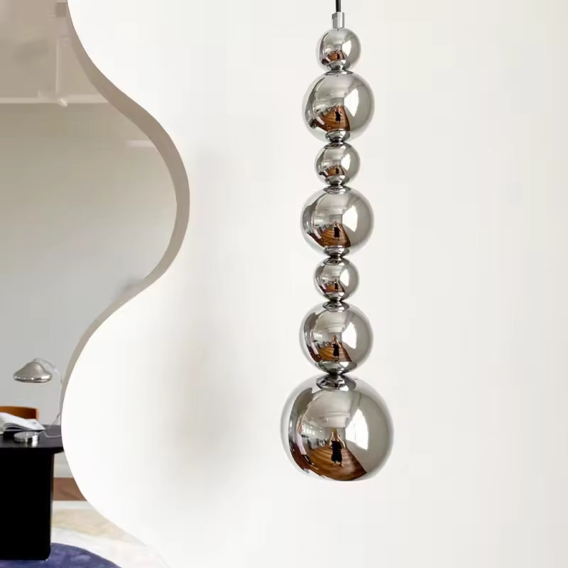 Cascade verticale de sphères chromées pour une suspension sculpturale au style contemporain et futuriste