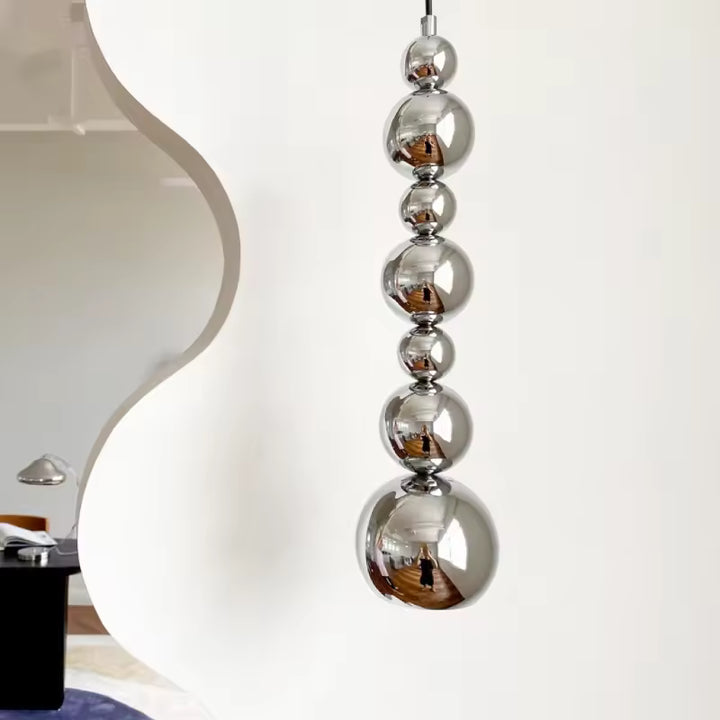 Cascade verticale de sphères chromées pour une suspension sculpturale au style contemporain et futuriste