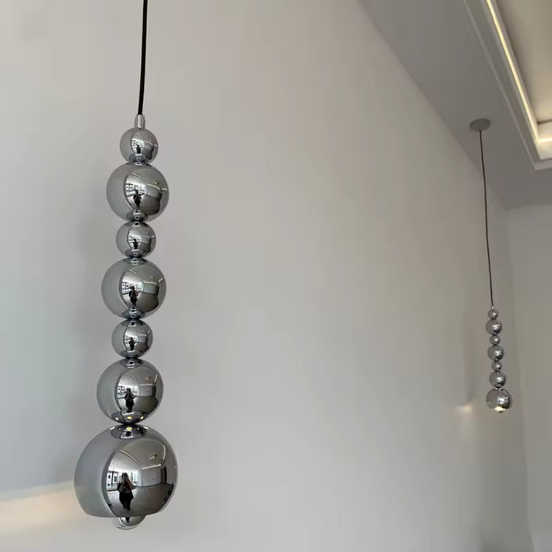 Deux suspensions en cascade de sphères chromées créent un effet sculptural au style moderne et contemporain