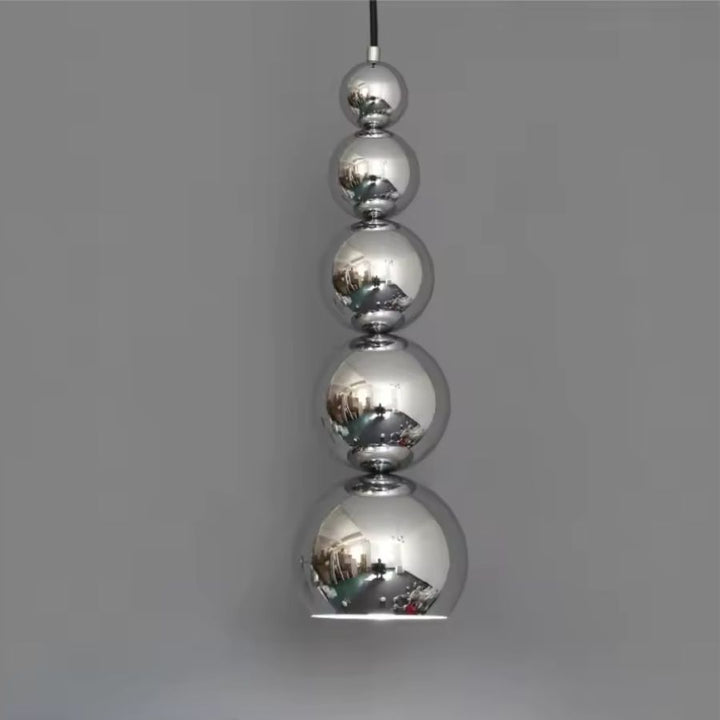 Alignement vertical de sphères chromées effet miroir pour une suspension design au style sculptural et contemporain